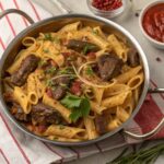 A bowl of One-Pot Beef and Cheddar Ranch Pasta garnished with cheese and herbs.