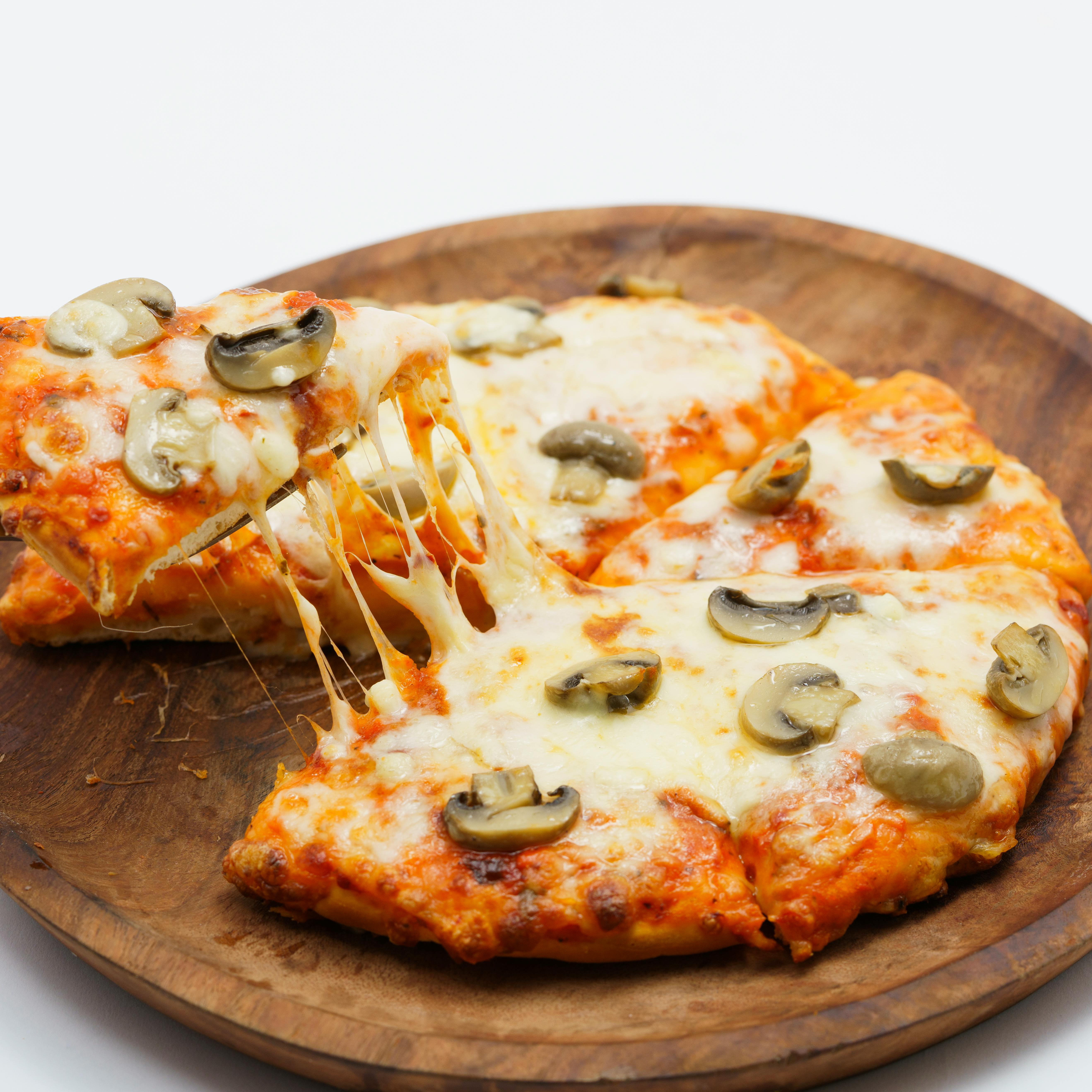 Close-up of a warm, cheesy mushroom pizza served on a wooden platter, perfect for food lovers.