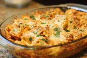 A hearty Chicken Enchilada Tortellini Bake topped with cheese and fresh cilantro