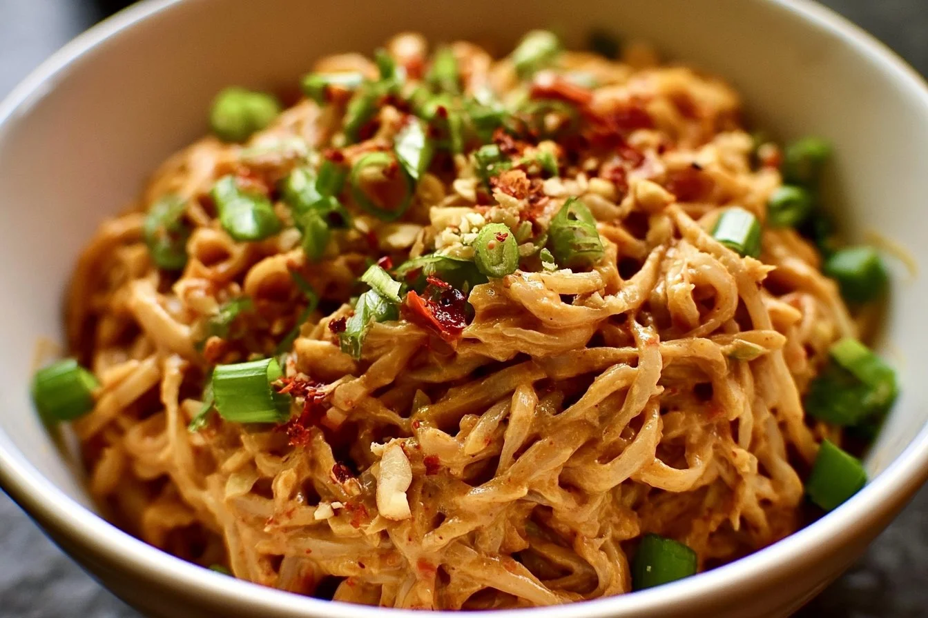 Spicy Peanut Butter Noodles 2 Bowl of spicy peanut butter noodles garnished with vegetables and herbs