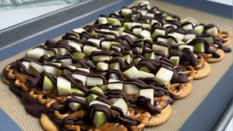 Delicious Caramel Apple Bark with nuts and chocolate on a wooden platter